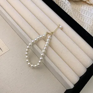 Detailed view of elegant white pearl necklace with adjustable gold clasp and extension chain