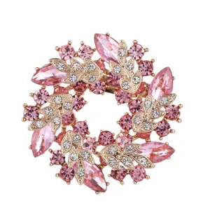 Makroansicht einer Vintage-Blumenbrosche mit rosa und klaren Kristallen in Goldfassung