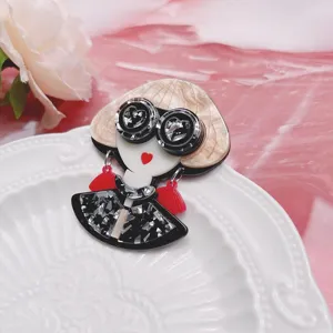 Vista detallada de un bonito broche de acrílico de niña de dibujos animados en un plato