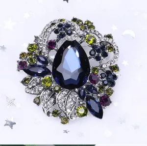 Detail of vintage Bohemian brooch with large blue teardrop crystal and colorful rhinestones