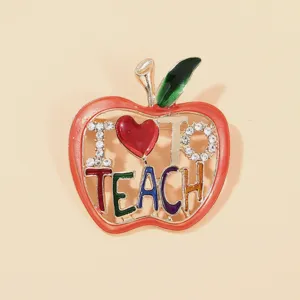 Detailed macro shot of apple brooch featuring 'I Love Teach' enamel and sparkling rhinestones