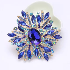 Dettaglio di un'elegante spilla a fiore con cristalli blu reale e finiture oro