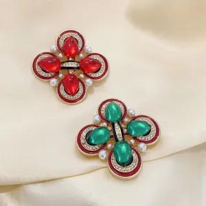 Détail de broches vintage de style cour avec pierres en verre colorées et perles fines