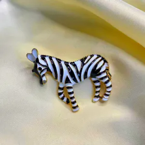 Detailed view of a vintage enamel zebra brooch with black and white stripes and gold finish