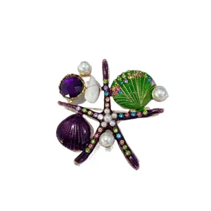 Detailed view of a vibrant purple starfish and green shell brooch featuring pearls