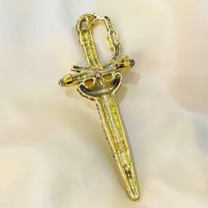 Close-up detail showing the back pin mechanism of the vintage gold sword brooch
