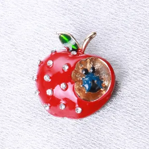 Detailed view of red enamel apple brooch with sparkling rhinestones and ladybug.