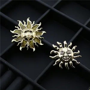 Gros plan détaillé de broches soleil vintage dorées avec émail pailleté et strass