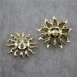 Détail de deux broches soleil célestes rétro en alliage d'or et émail pailleté vert