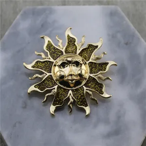 Détail d'une broche soleil dorée vintage avec visage céleste et émail pailleté