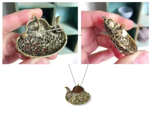 Detailansicht der Wunderlampe-Brosche mit Vorderseite und Anstecknadel auf der Rückseite.