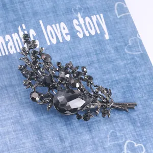 Gros plan d'une broche bouquet vintage en cristal avec pierre en forme de goutte.