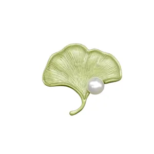 Elegante broche vintage de hoja de ginkgo lacada en verde con una perla blanca única