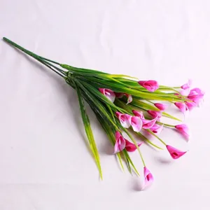 Detailed macro shot of artificial pink and white Calla Lily flowers with green leaves