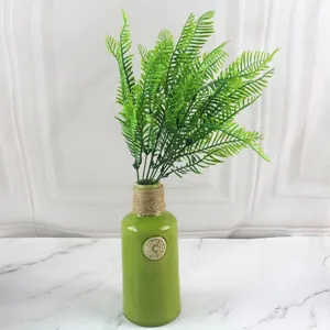 Artificial green Persian fern plant in a rustic ceramic vase for home and wall decoration