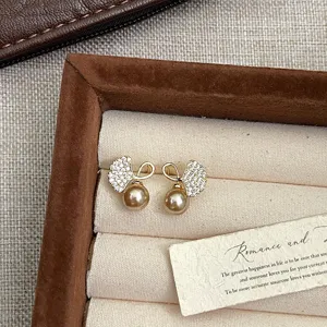 Elegantes pendientes de hoja de ginkgo dorada con circonitas y perlas champán