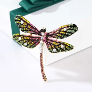Close-up of vintage colorful dragonfly brooch with sparkling multicolor rhinestones.