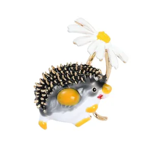 Macro view of cute enamel hedgehog brooch holding a delicate white daisy accessory