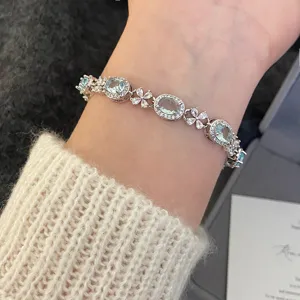 Vue détaillée d'un élégant bracelet en pierres bleu ciel avec des accents floraux en zircon.