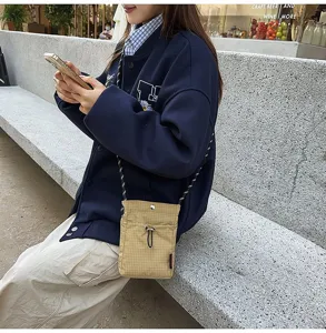 Vista dettagliata della borsa a tracolla per cellulare a quadretti beige in stile casual.