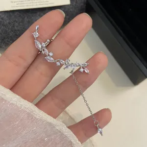 Dettaglio ear cuff in argento con zirconi a foglia e catena con nappe luccicanti