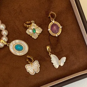 Gros plan de pendentifs en nacre et papillon dorés avec des accents de zircon sur velours