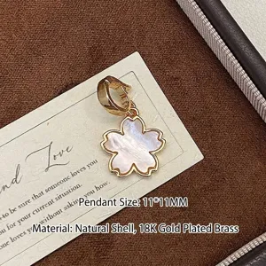 Vue détaillée du pendentif fleur de cerisier 11x11mm en nacre naturelle et cuivre plaqué or