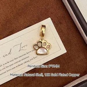 Vue détaillée d'un pendentif patte de chat plaqué or avec incrustations de nacre