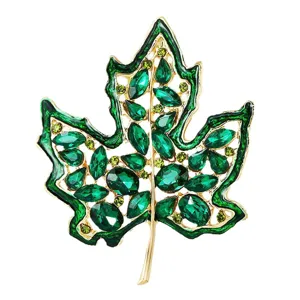 Elegante broche de hoja de arce dorado con vibrantes cristales verdes brillantes