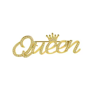 Close-up van elegante goudkleurige Queen-broche met fonkelende strass en een kroon.