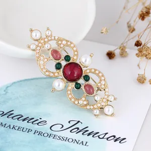 Close-up of vintage baroque style brooch with red gemstones and pearls