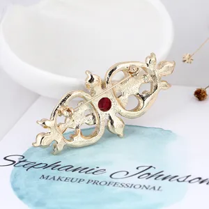 Detailed back view of a vintage gold Baroque medal brooch with a red gemstone center