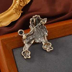 Vue arrière détaillée d'une broche caniche vintage avec finition or antique et fermoir