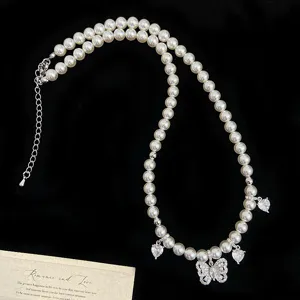Vista dettagliata di un ciondolo a farfalla in zirconia su un'elegante collana di perle
