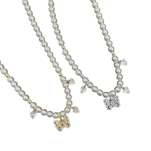 Elegante collana di perle con farfalla in zircone e pendenti a cuore oro e argento.
