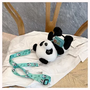 Primer plano de una mochila de peluche de panda con correa verde estampada y bordado.