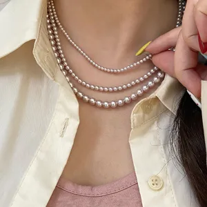 Detailed view of triple-layered French style pink pearl necklace on elegant model neck