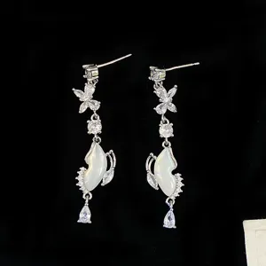 Detailed view of elegant silver butterfly drop earrings with shimmering shells and crystals