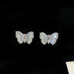 Detailed view of elegant natural shell butterfly stud earrings with sparkling zircons.