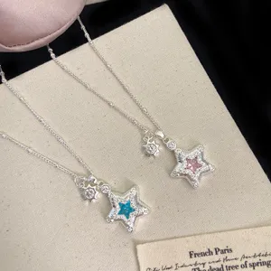 Detail of micro-pave zircon star pendant necklace with sun charm in silver finish