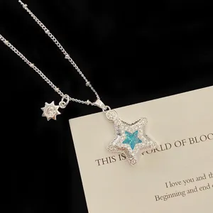 Close-up of a silver star pendant necklace with micro-pave zircons and a blue center stone