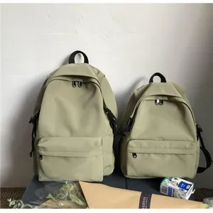 Side-by-side comparison of large and small minimalist water-repellent nylon backpacks.