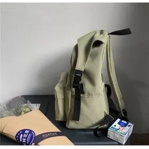 Side view of khaki nylon water-repellent backpack showing strap and buckle detail