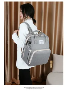 Seitenansicht eines grauen multifunktionalen Wickelrucksacks, getragen von einem Model
