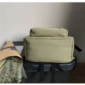 Detail view showing the bottom and back structure of a green water-resistant nylon backpack