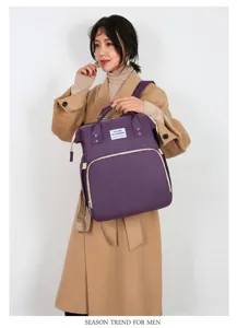 Detailaufnahme der multifunktionalen lila Windeltasche, getragen von einem Model