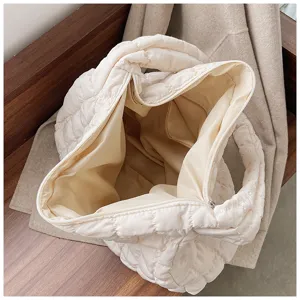 Quilted puffer tote bag interior detail, soft down cotton casual dumpling handbag lining.