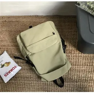 Close-up detail of a light green water-resistant nylon student backpack on a mat