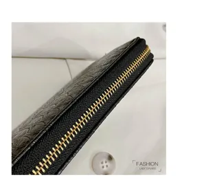 Close-up detail of black crocodile embossed lady's long wallet with golden zipper teeth.