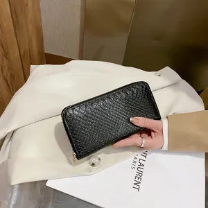 Detailed view of women's black crocodile pattern long wallet with zip-around closure